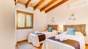 A room with two beds, a window, and a ceiling fan. - Villa Olivo by Villa Plus (Mallorca)
