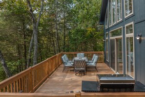 A deck with a table and chairs, surrounded by trees. - Raynor Shine Chalet by Innsbrook Vacations! (Innsbrook)