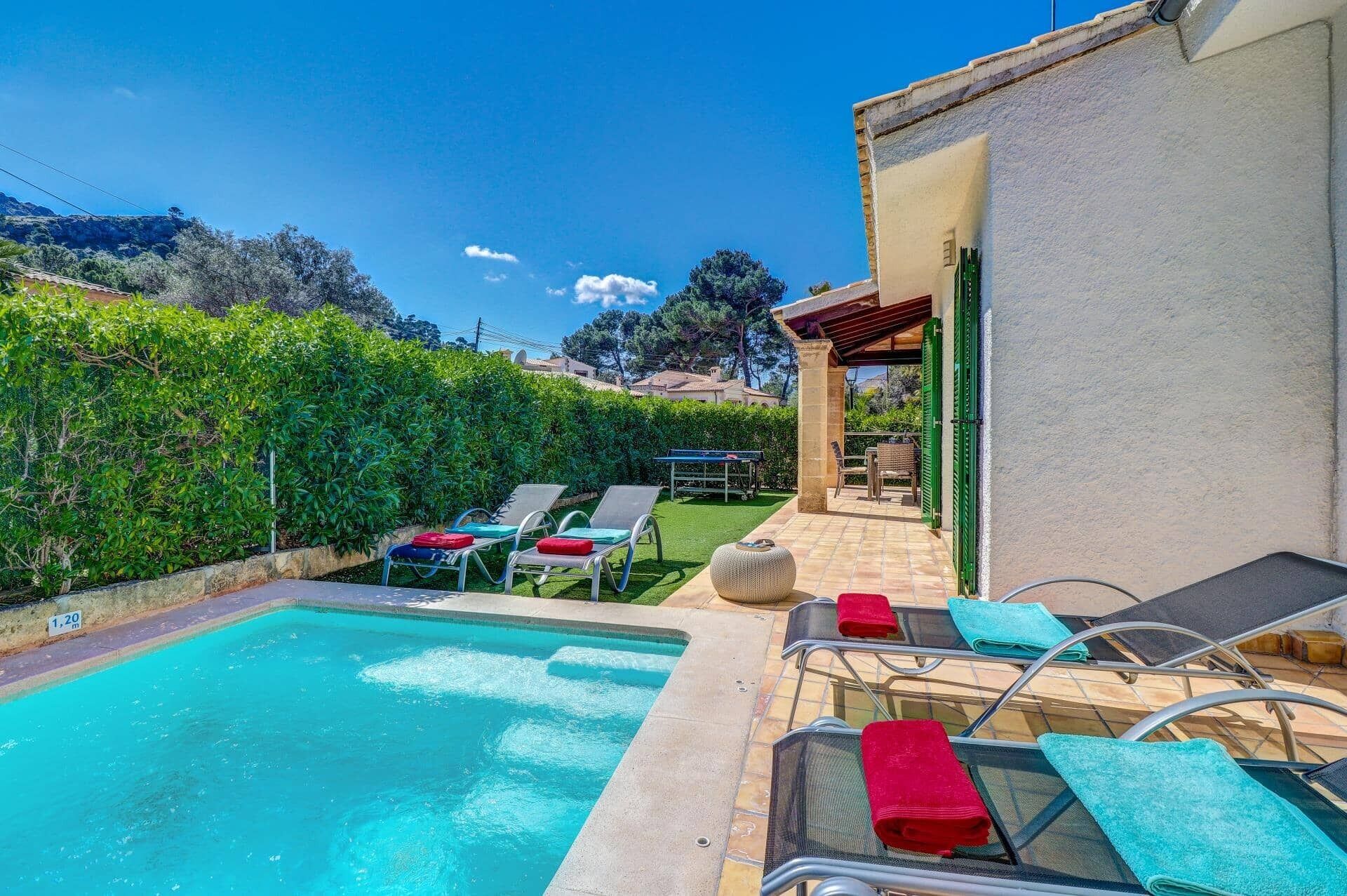 A swimming pool with lounge chairs and a pergola.