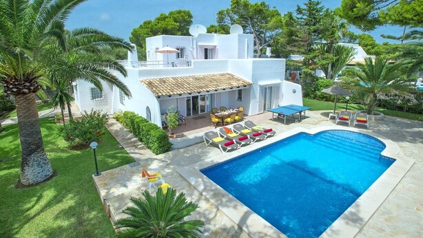 A white villa with a swimming pool, outdoor seating, and lush greenery. - Villa Reco by Villa Plus (Felanitx)