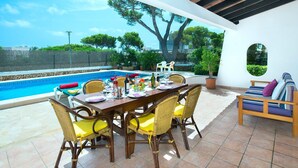 An outdoor dining area with a pool, wicker chairs, and a view of the sea. - Villa Reco by Villa Plus (Felanitx)
