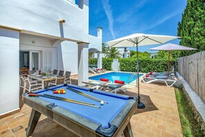 A pool area with a pool table, lounge chairs, and umbrellas. - Villa Roca Viva by Villa Plus (Cala d'Or)