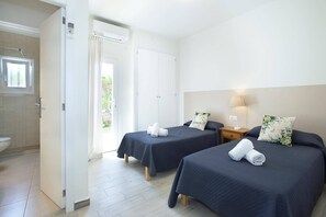 A hotel room with two beds, a bathroom, and a view of the outdoors. - Villa Roca Viva by Villa Plus (Cala d'Or)