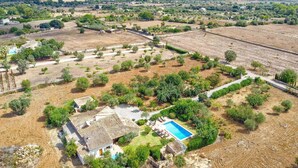 An aerial view of a residential area with a house featuring a tiled roof, a swimming pool, and a garden. - Villa Garriguer by Villa Plus (Mallorca)