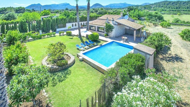 A villa with a swimming pool, surrounded by lush greenery and a mountainous backdrop. - Villa Francisca by Villa Plus (Mallorca)