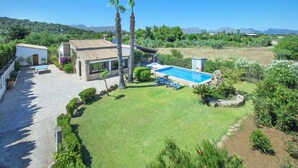 A house with a swimming pool, surrounded by a well-maintained lawn and palm trees. - Villa Francisca by Villa Plus (Mallorca)