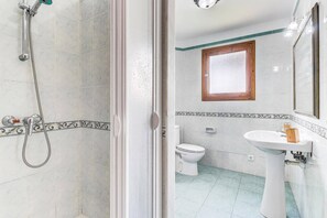 A bathroom with a shower, toilet, and sink.