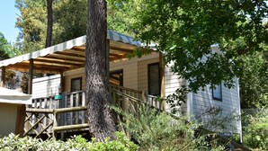 A cabin with a wooden deck, a covered porch, and a staircase leading to the entrance.