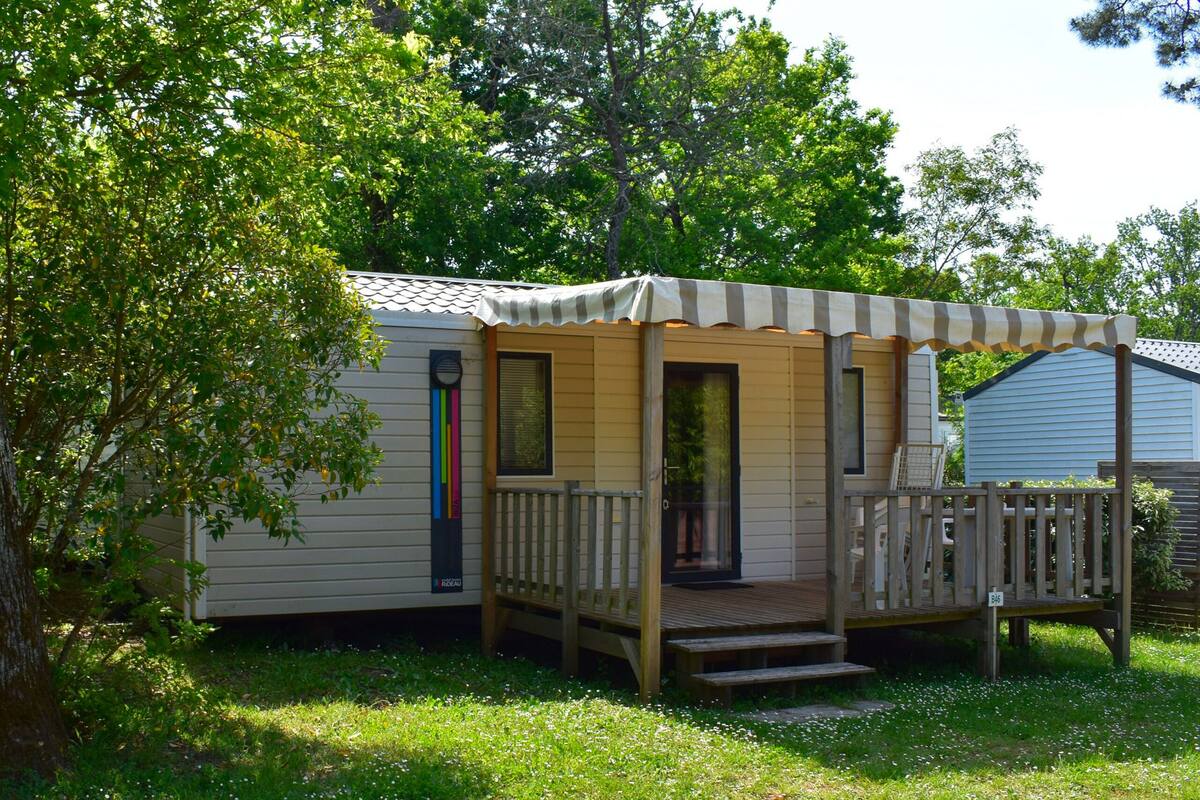 A mobile home with a porch and a small deck.