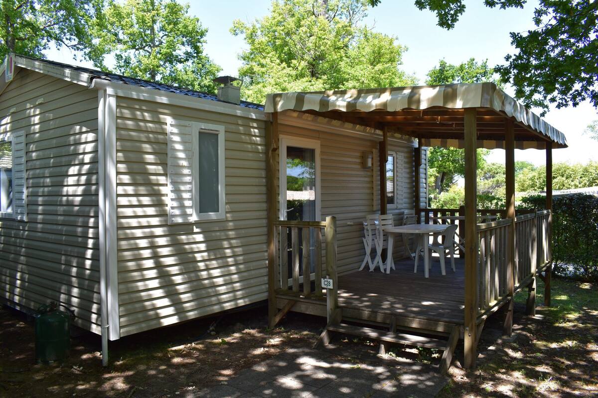 A mobile home with a deck and outdoor seating area.