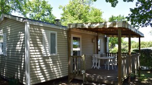 A mobile home with a deck and outdoor seating area.