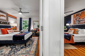 A hotel room with two beds, a desk, a chair, a ceiling fan, and a large window. - NEWLY RENOVATED, 3 blocks from AU, Game Day House “Caddy’s Shack” (Auburn)