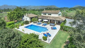 A villa with a swimming pool, outdoor seating, and a view of the surrounding landscape. - Villa S'Olivellas by Villa Plus (Mallorca)