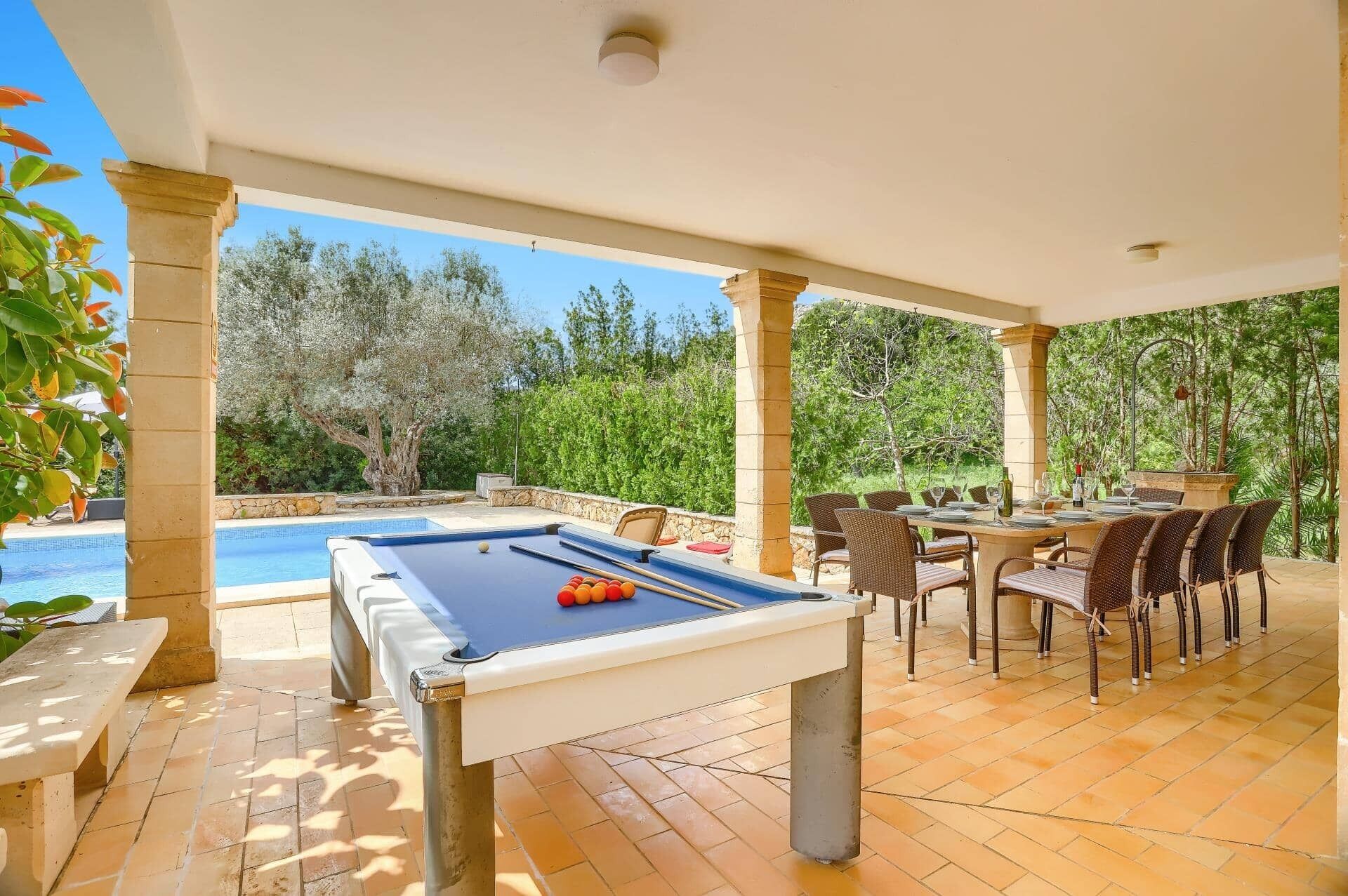 Un espace extérieur avec une piscine, une table de billard et des sièges.