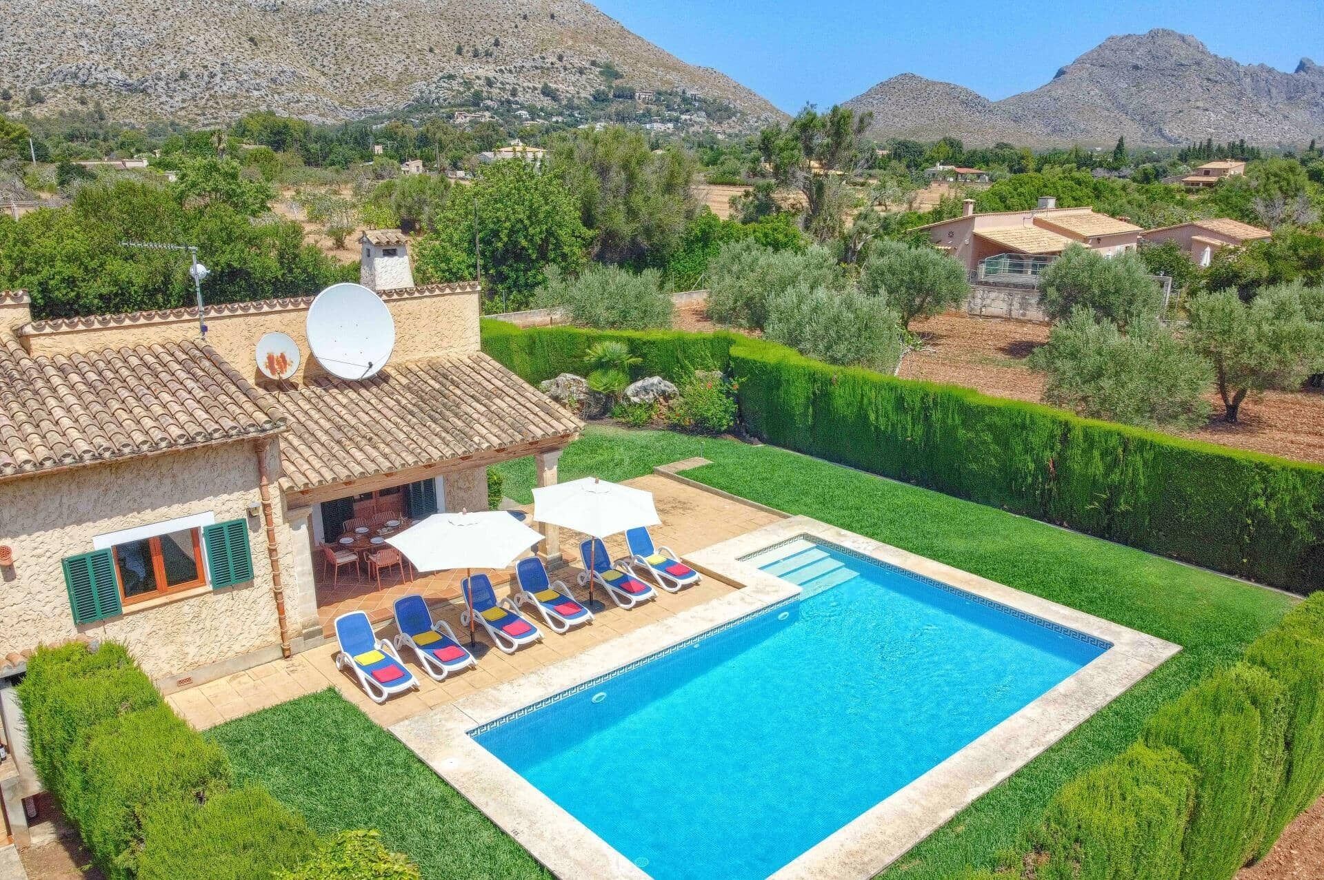 A property with a swimming pool, outdoor seating, and a view of the surrounding landscape.