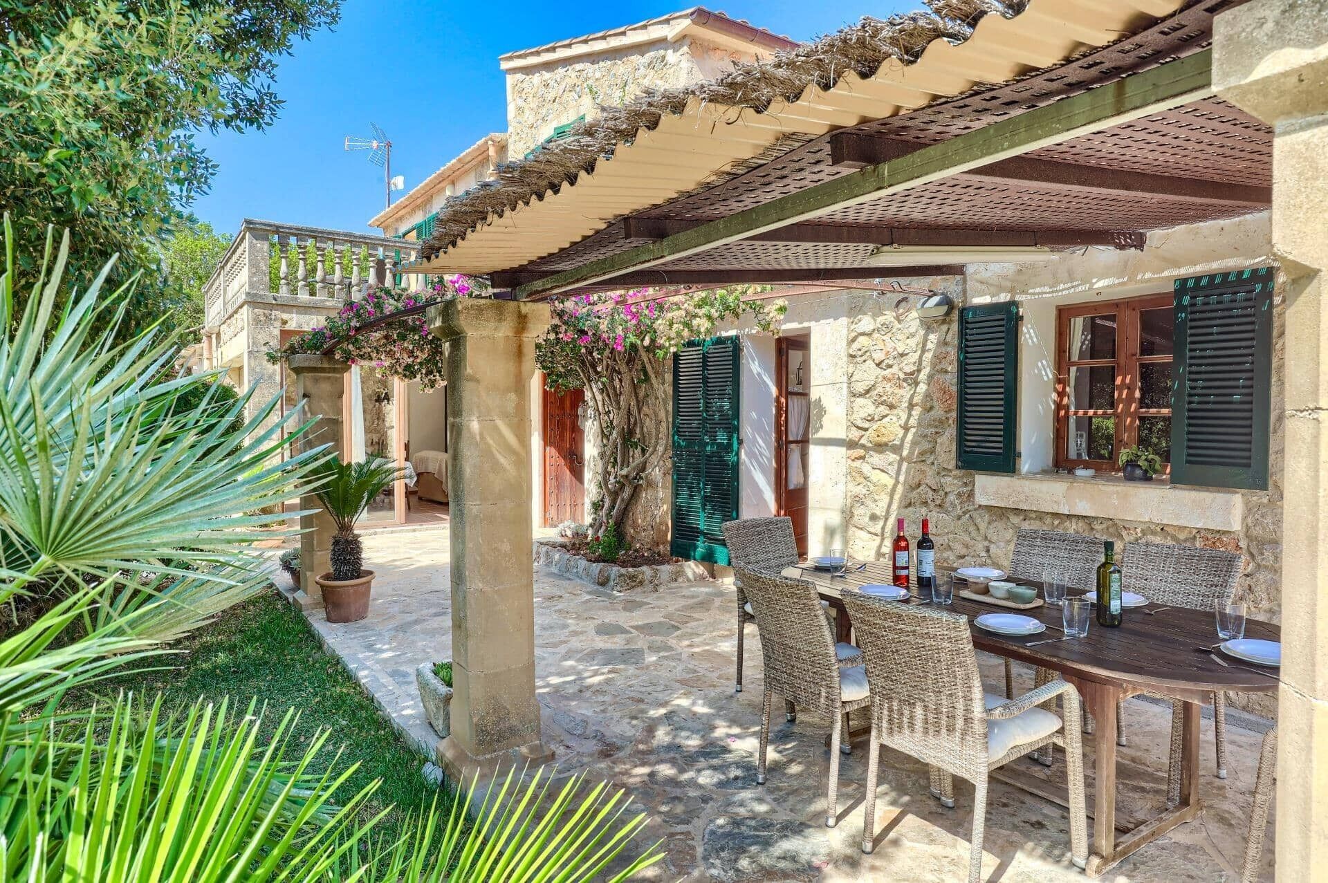 A stone building with a covered patio, outdoor seating, and a view of the surrounding area.