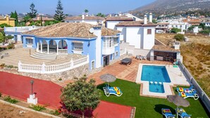 A large house with a swimming pool, outdoor seating, and a view of the surrounding area. - Villa Tia Ana by Villa Plus (Fuengirola)