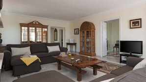 Un salon comprenant un canapé, une table basse, un téléviseur et des objets de décoration.