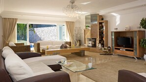 A spacious living room with a sofa, coffee table, and a fireplace.