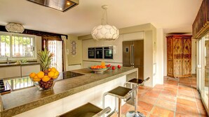 A modern kitchen with a central island, stainless steel appliances, and a decorative ceiling light.