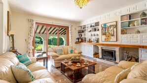 A living room with a fireplace, a sofa set, a coffee table, and a bookshelf.