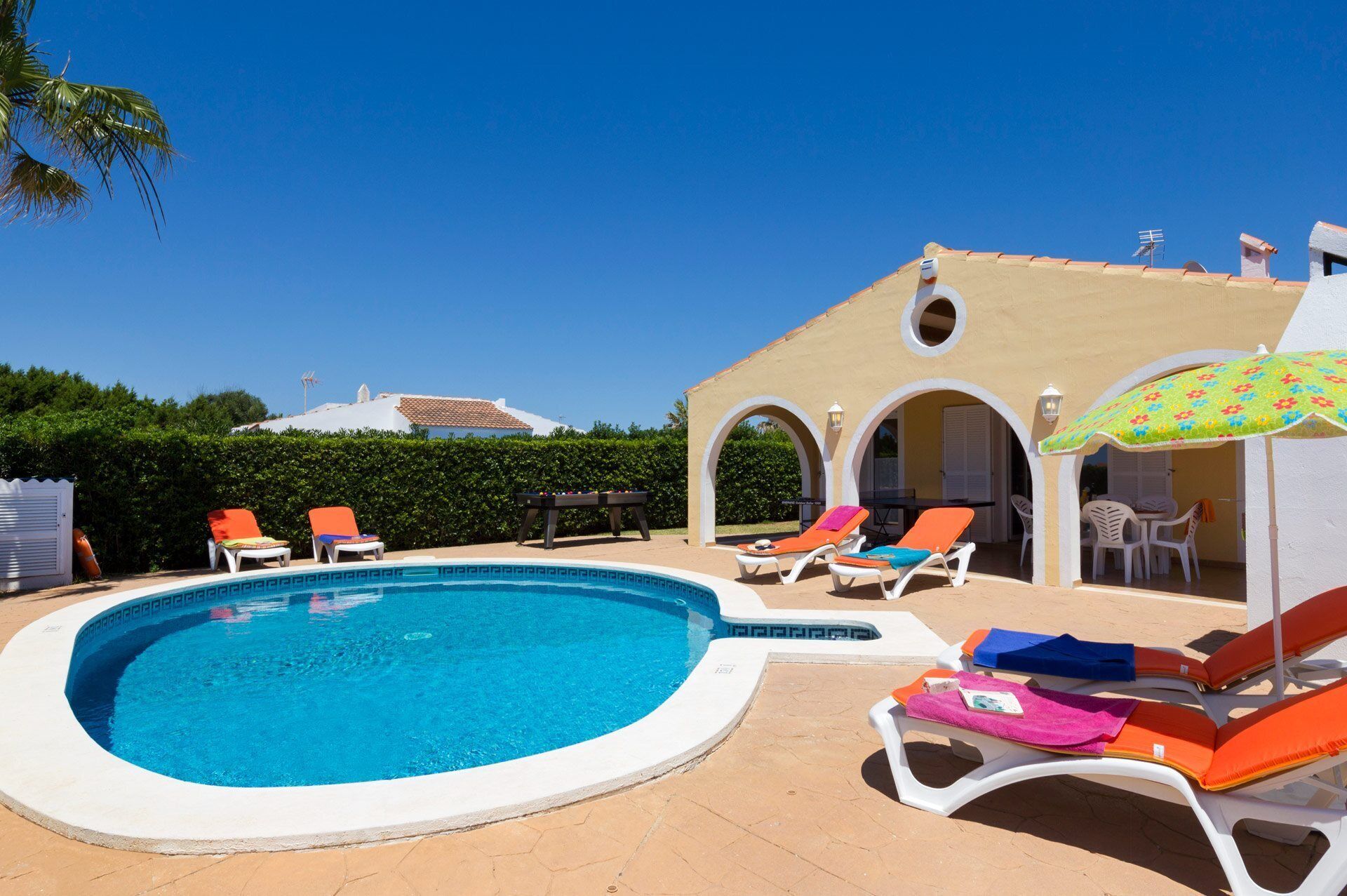 A swimming pool with lounge chairs and a covered seating area.