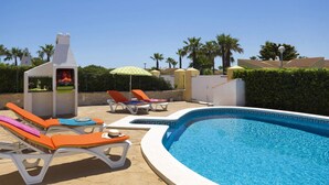 A poolside area with lounge chairs, a barbecue grill, and a clear blue pool. - Villa Neptune by Villa Plus (Cap d'Artrutx)