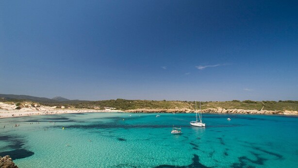 A coastal area with clear turquoise waters, boats, and a sandy beach. - Villa Serafina by Villa Plus (Son Parc)