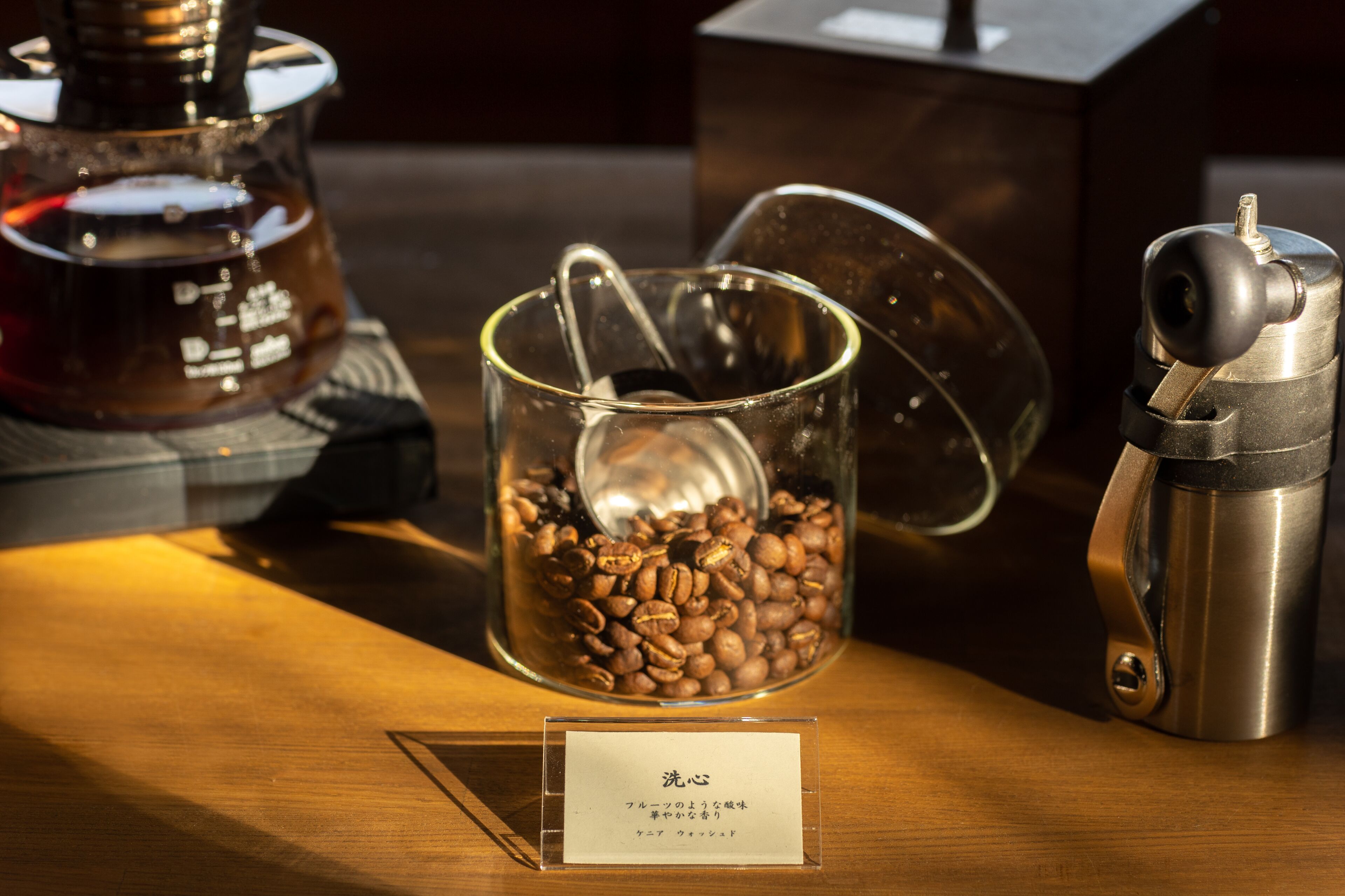 A coffee machine, a glass container with coffee beans, and a metal container with a lid.
