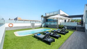 A rooftop pool area with a swimming pool, lounge chairs, and a lifebuoy. - Villa Lola by Villa Plus (Corralejo)