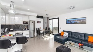 A modern apartment with a kitchen, dining area, and living room. - Villa Lola by Villa Plus (Corralejo)