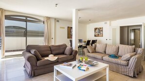 A spacious living room with two sofas, a coffee table, and a dining area in the background. - Villa Pino by Villa Plus (Corralejo)