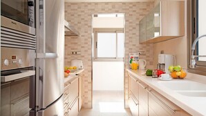 Eine moderne Küche mit Einbauofen, Kaffeemaschine und Fenster.