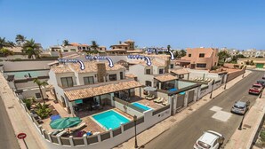 Ein Wohnkomplex mit mehreren Villen, darunter Villa Nanda, Villa Jenny, Villa Pino und Villa Juliana, mit Pool und Straßenansicht.