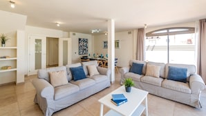 A modern living room with two sofas, a coffee table, and a dining area in the background. - Villa Sirena by Villa Plus (Corralejo)