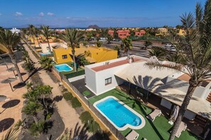 Ein Resort mit mehreren Pools, Palmen und Blick aufs Meer.