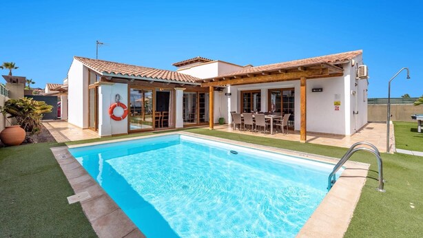 A two-story house with a swimming pool, a covered patio, and a lifebuoy on the door. - Villa Sherry by Villa Plus (Corralejo)