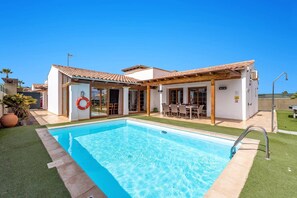 A two-story house with a swimming pool, a covered patio, and a lifebuoy on the door.