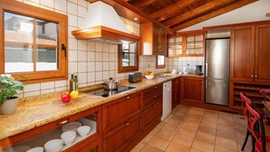 Una cocina con armarios de madera, un refrigerador de acero inoxidable y una encimera de granito.
