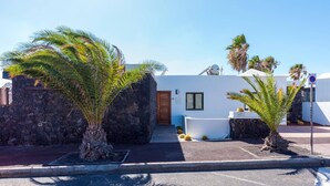 A modern building with a stone wall entrance, a white facade, and a sign indicating 'Casa Kike.' - Villa Kikay by Villa Plus (Tías)