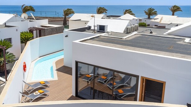 A rooftop pool area with a clear view of the sea, lounge chairs, and a glass-enclosed dining area. - Villa JJ Beach by Villa Plus (Tías)