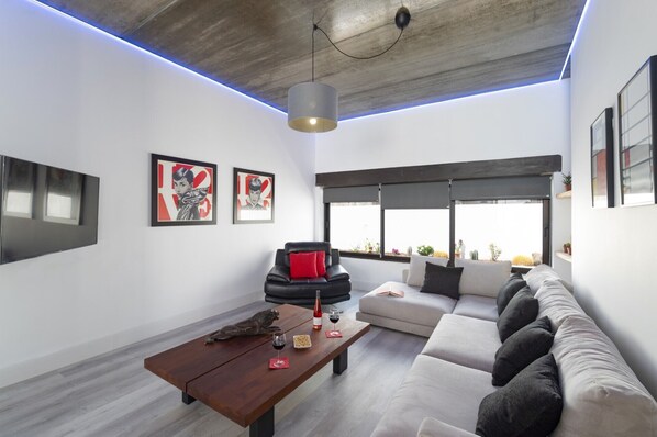 Un salon moderne avec un canapé, une table basse et des œuvres d’art accrochées aux murs.