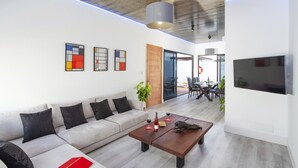 A modern living room with a sofa, coffee table, and artwork on the wall. - Villa JJ Beach by Villa Plus (Tías)
