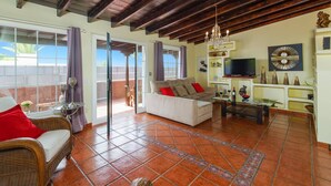 Una sala de estar con un sofá, un televisor y un adorno de pared.