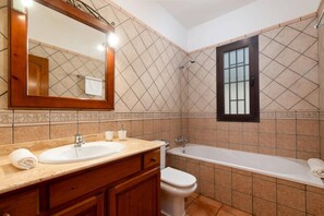 A bathroom with a sink, toilet, and bathtub. - Villa Clarybel by Villa Plus (Playa Blanca)