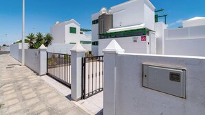 Un edificio blanco con entrada porticada, una ventana pequeña con contraventanas verdes y un cartel que dice 'VILLA ORO'.