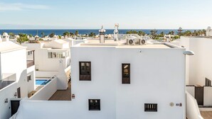 Un edificio blanco con muchas ventanas y un área de piscina.