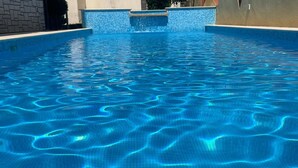 Ein Swimmingpool mit klarem, blauem Wasser und einer gefliesten Kante.