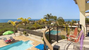A pool area with lounge chairs and a view of the sea. - Villa Kassiopeia by Villa Plus (Peyia)