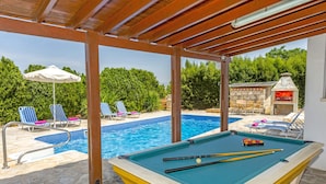 A pool area with a pool table, lounge chairs, and a barbecue area. - Villa Theo Sapphire by Villa Plus (Latchi)